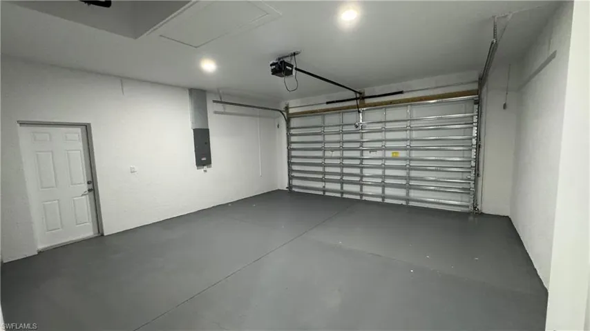 Garage with electric panel and a garage door opener