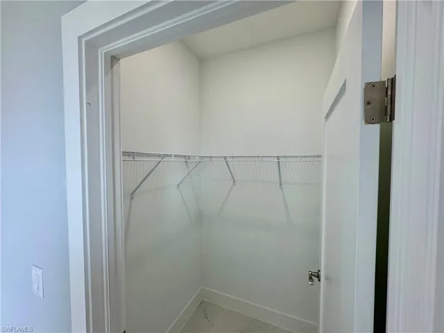 Walk in closet with marble finish flooring