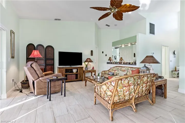 Living room with ceiling fan and a towering ceiling