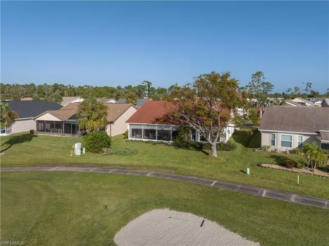 View of front of property featuring a sunroom and a front lawn