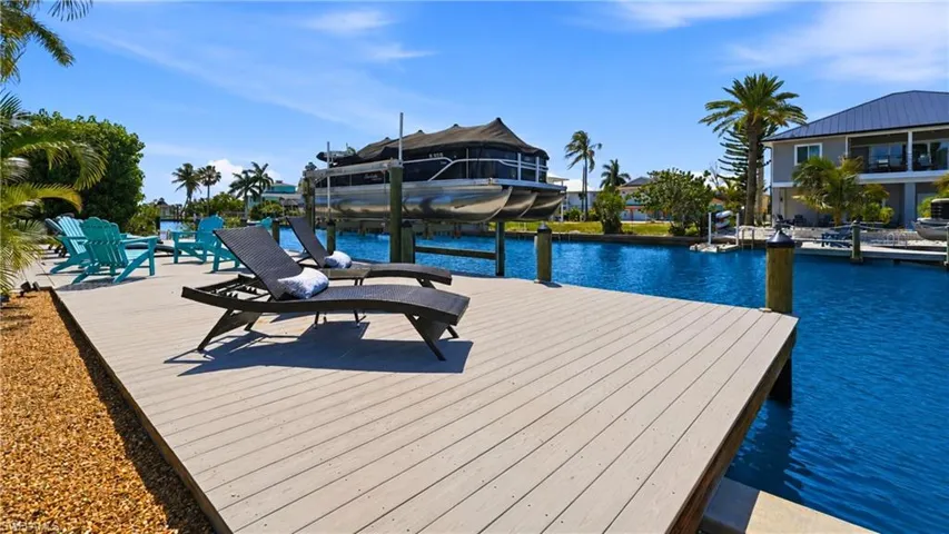 Waterfront dock featuring composite decking, direct canal access, and an integrated boat lift - Virtually Edited Image