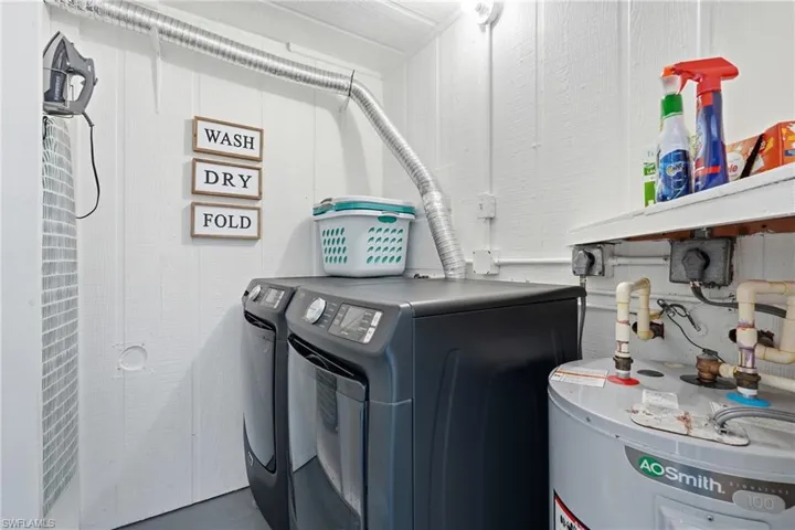 Dedicated laundry area featuring white vertical paneling and a visible water heater - Virtually Edited Image