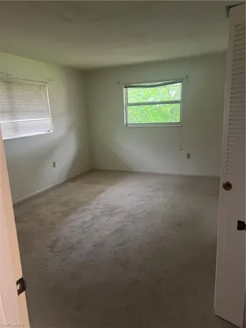 Unfurnished room featuring carpet floors and baseboards
