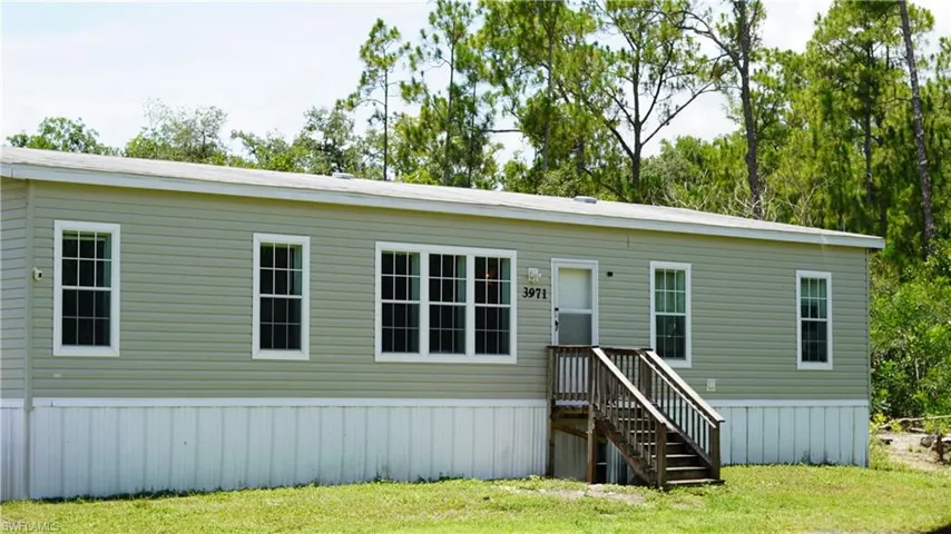 Single-story structure featuring light green vinyl siding and white trim