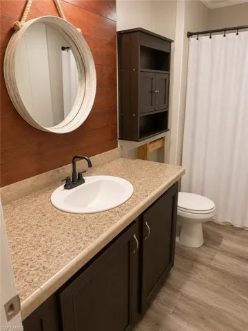 Bathroom vanity with an integrated sink, dark wood-finish cabinetry, and a speckled countertop