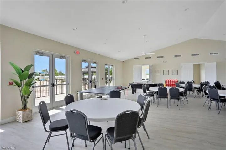 Dining area featuring french doors, vaulted ceiling, light wood-type flooring, and a ceiling fan