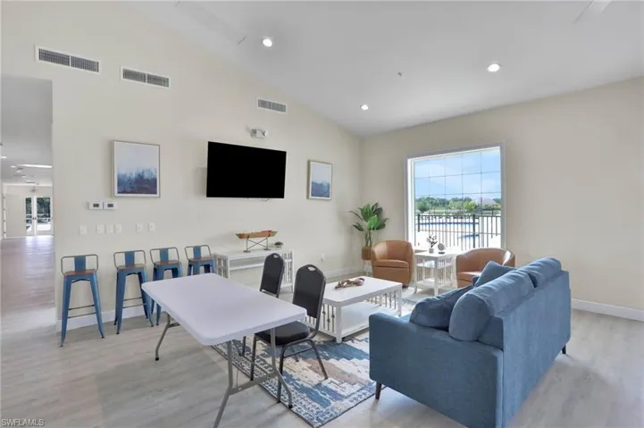 Living room with vaulted ceiling, light wood-style flooring, recessed lighting, and ceiling fan