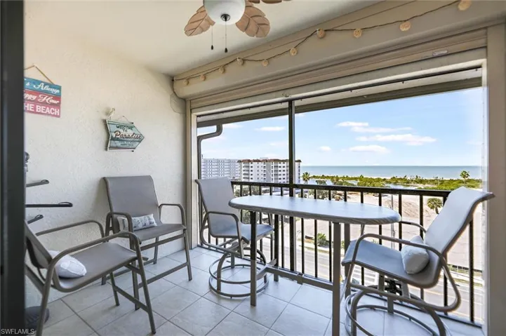 Balcony featuring a ceiling fan and a water view