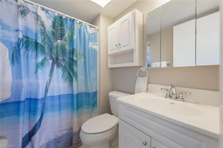 Full bathroom featuring curtained shower and vanity