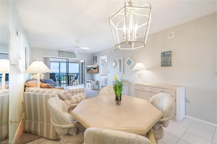 Dining space with a ceiling fan, hanging lights, and tile patterned flooring