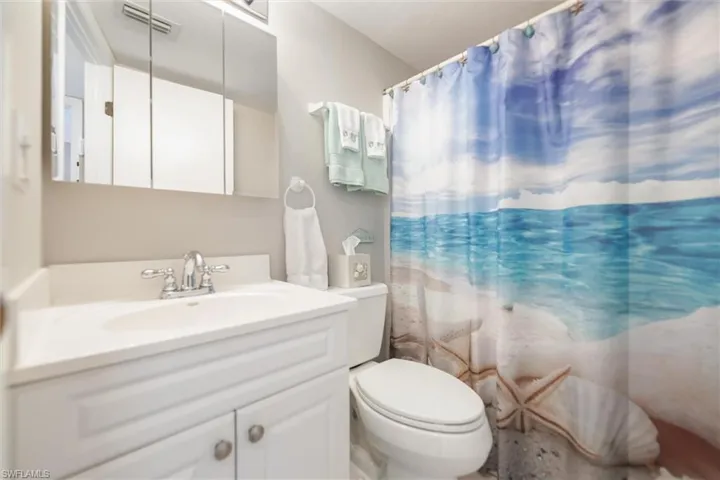 Bathroom with curtained shower and vanity