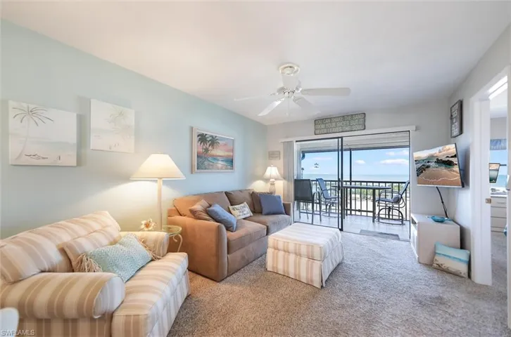 Living area featuring a ceiling fan and carpet flooring