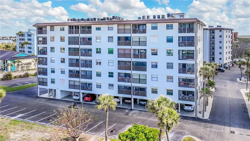 View of apartment building / complex with uncovered parking