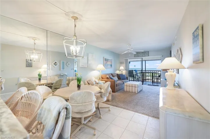 Living area featuring ceiling fan, a chandelier, and carpet