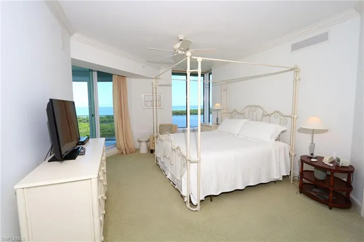 Bedroom with light carpet, a ceiling fan, visible vents, and crown molding