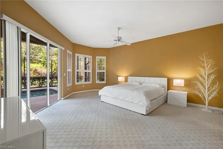 Carpeted bedroom with access to exterior, ceiling fan, and baseboards