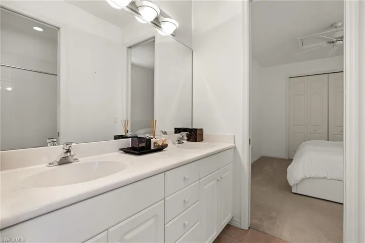 Bathroom featuring tile patterned flooring, double vanity, and a sink