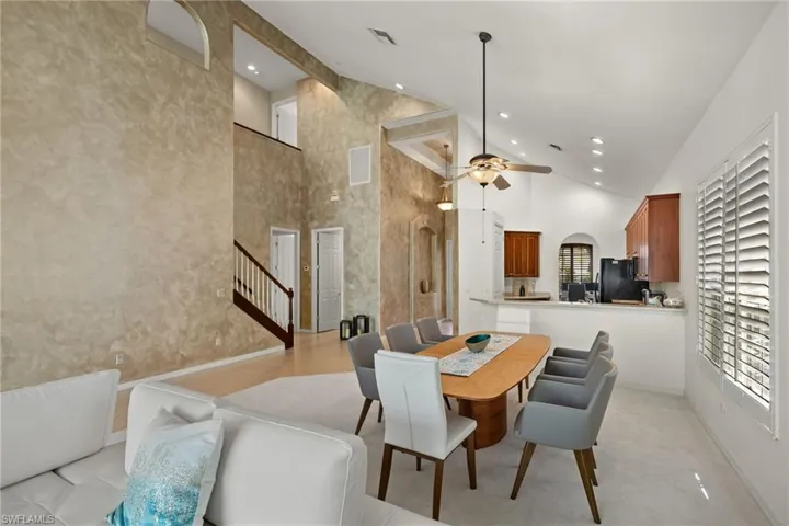 Dining room with visible vents, a wealth of natural light, high vaulted ceiling, and a ceiling fan