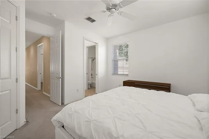 Bedroom with light carpet, ceiling fan, baseboards, and visible vents