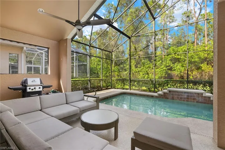Pool with a patio area, ceiling fan, glass enclosure, and an outdoor hangout area