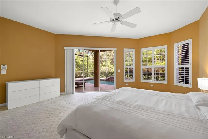 Unfurnished bedroom featuring carpet floors, access to exterior, and a ceiling fan