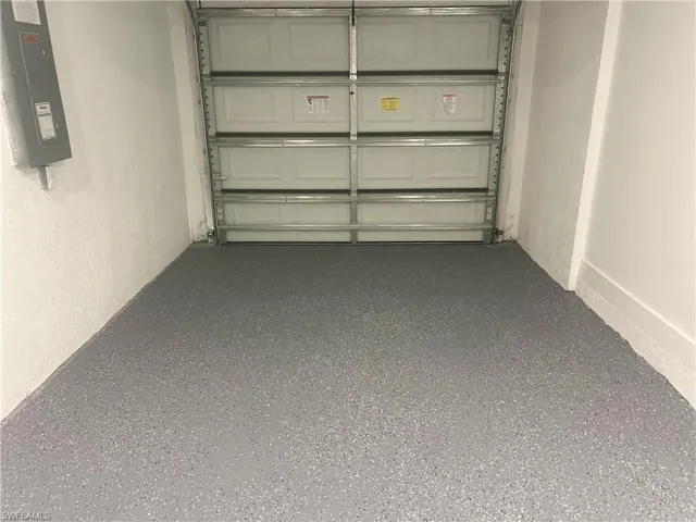 Garage featuring electric panel and a textured wall