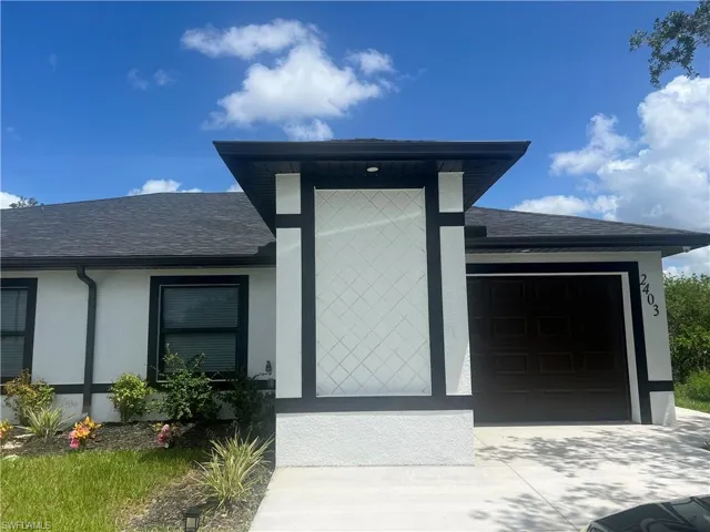View of front facade with a garage, concrete driveway, a shingled roof, and stucco siding