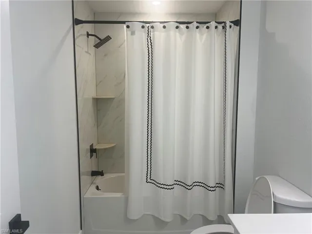 Bathroom with shower / bathtub combination with curtain and vanity