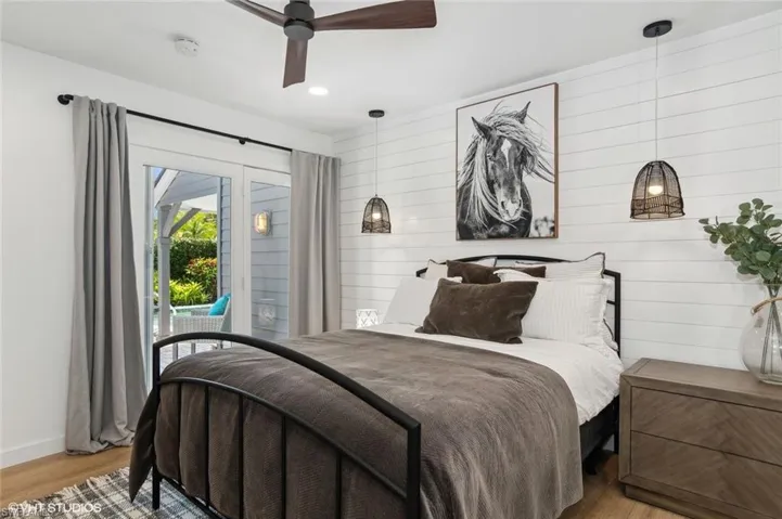Bedroom with access to outside and pool area, and ceiling fan