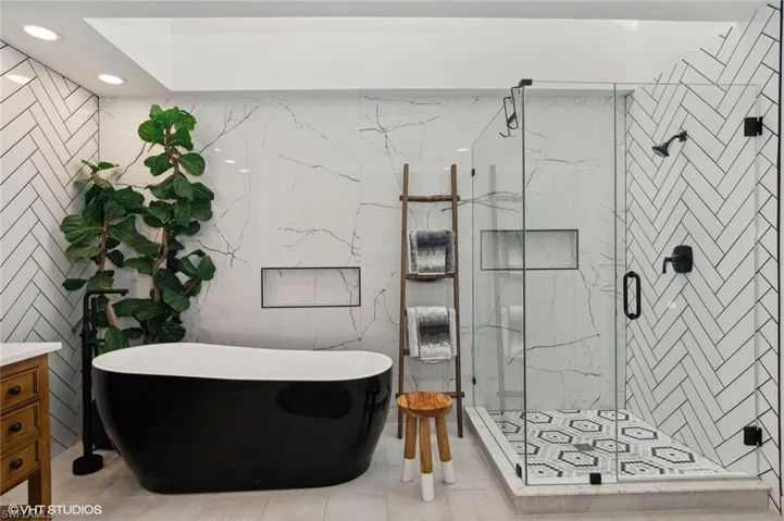 Bathroom with tile walls, vanity, and soaking tub.