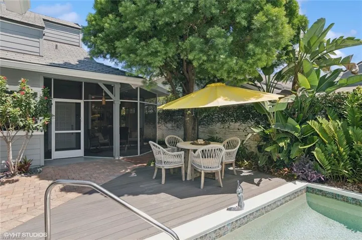 Wooden deck with screened in porch and landscaping