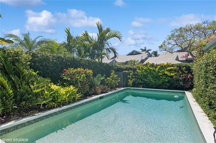 View of pool with a deck and landscaping