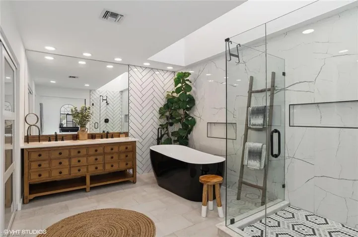 Master Bathroom featuring walk in shower,  tile floors, and vanity with double sinks and soaking tub
