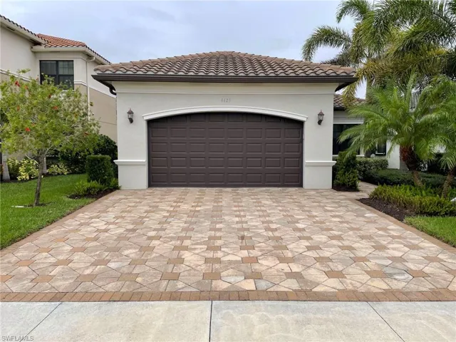 Garage featuring decorative driveway