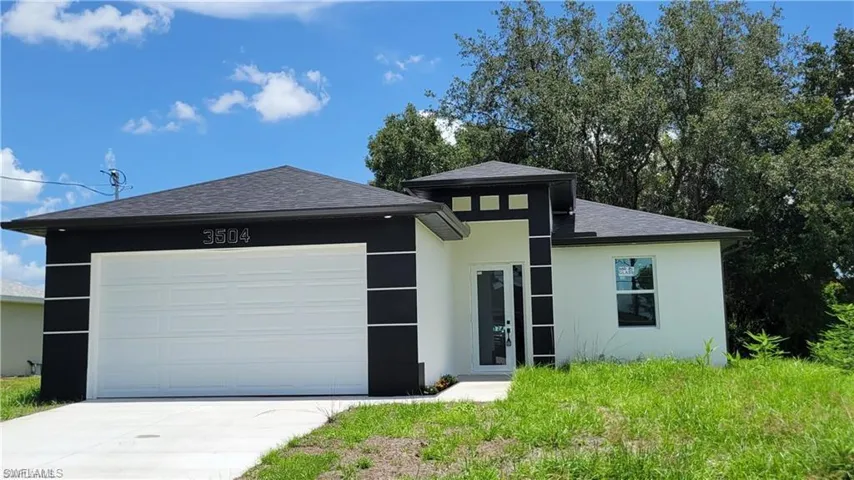 Single-story exterior featuring high-contrast stucco detailing, a multi-paneled garage door, a hip roof with architectural shingles, and a paved concrete driveway