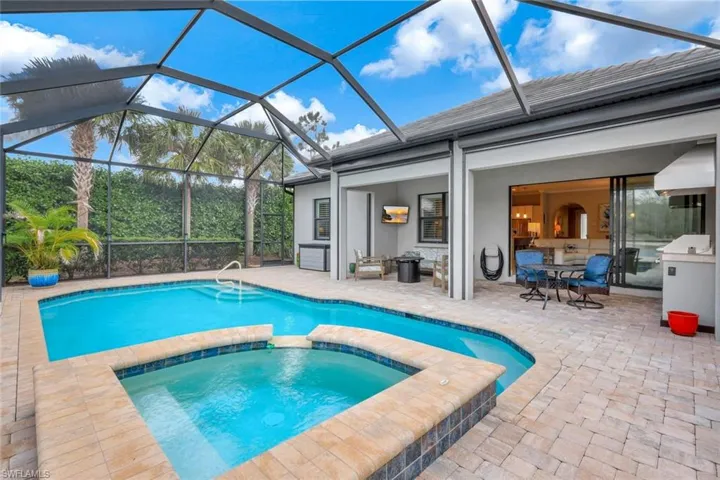 View of swimming pool with connected hot tub
