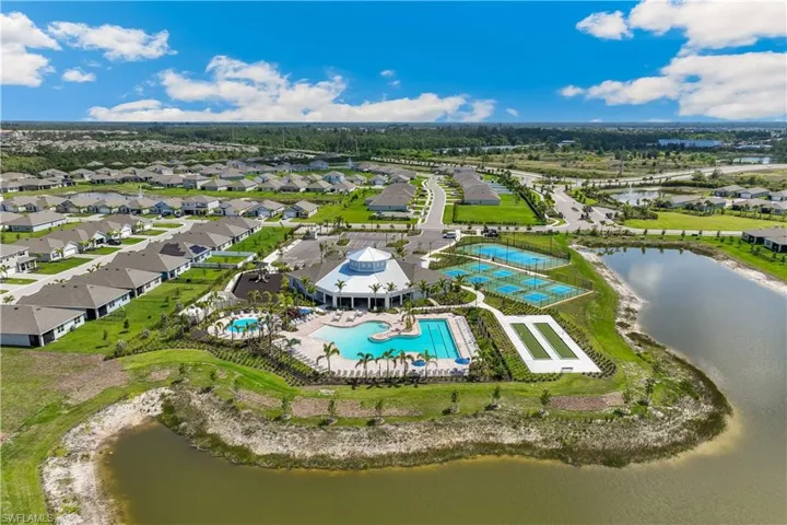 Aerial view of residential area featuring a pool area and a nearby body of water
