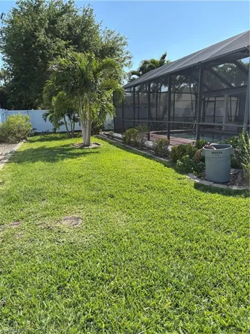 View of yard featuring a lanai and fence