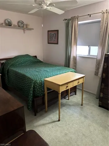 Carpeted bedroom with a ceiling fan