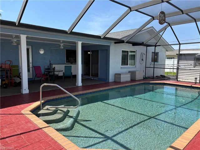 Outdoor pool with a lanai, a patio, and ceiling fan