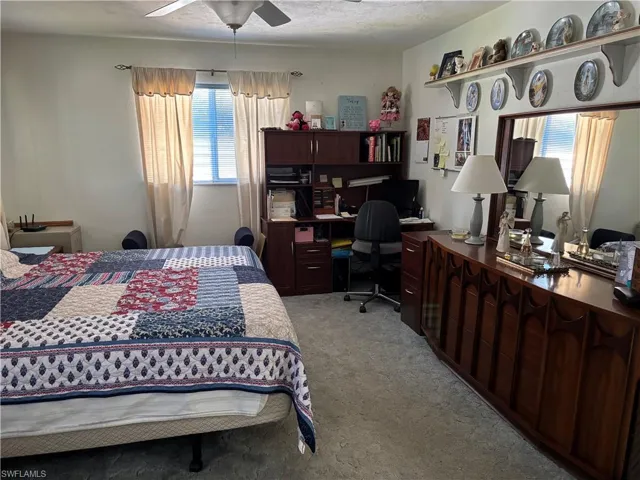 Bedroom featuring light carpet and a ceiling fan