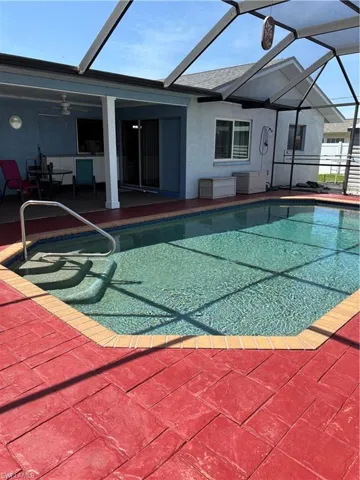 Pool featuring a patio area, glass enclosure, and a ceiling fan