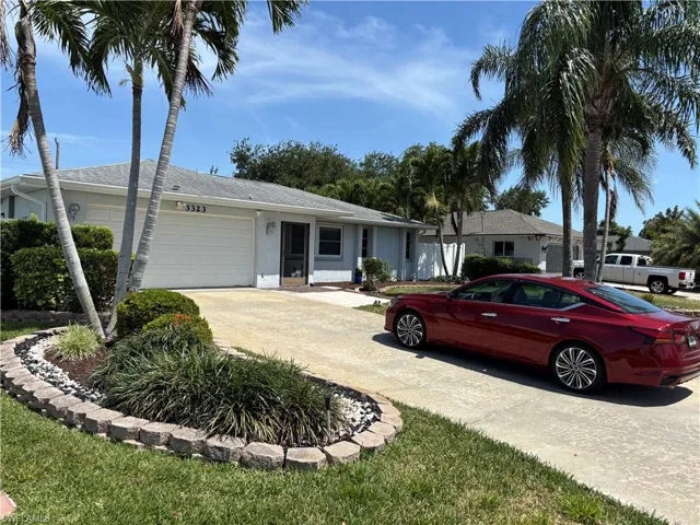 Ranch-style home with a garage, stucco siding, and concrete driveway
