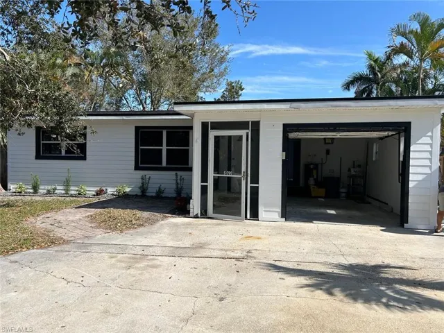 View of front of property featuring concrete driveway and water heater