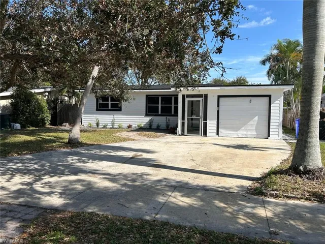 View of front facade with driveway and a garage