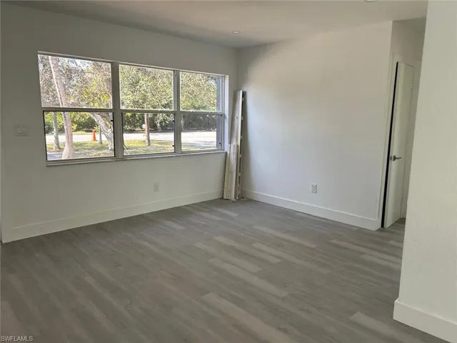 Unfurnished room with wood finished floors and baseboards