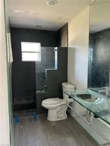 Bathroom with wood finished floors and tiled shower