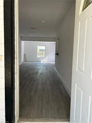 Corridor with wood finished floors and baseboards