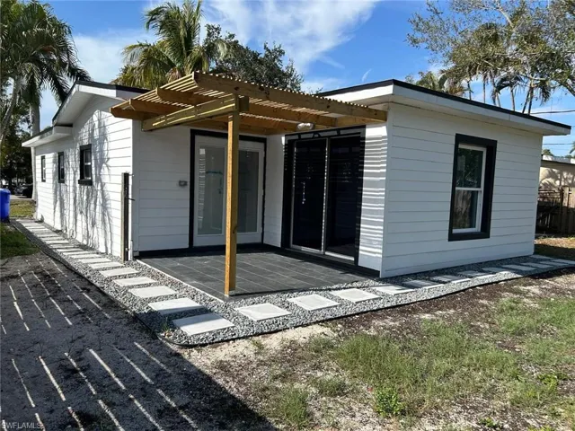 Rear view of house featuring a pergola and a patio