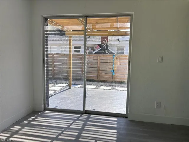 Doorway featuring a textured wall and baseboards